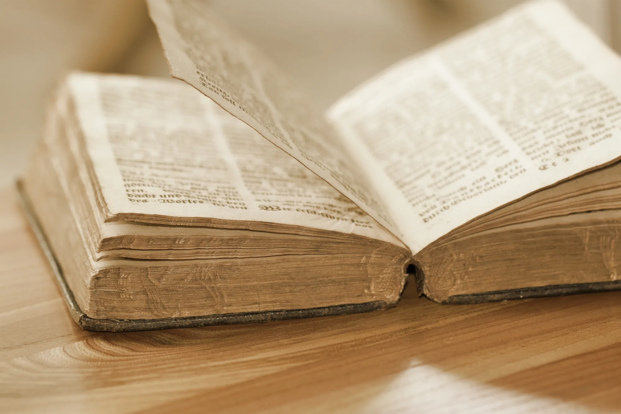 An antique book lying open, its pages softly lit